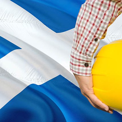 Scottish Engineer is holding yellow safety helmet with waving Sc